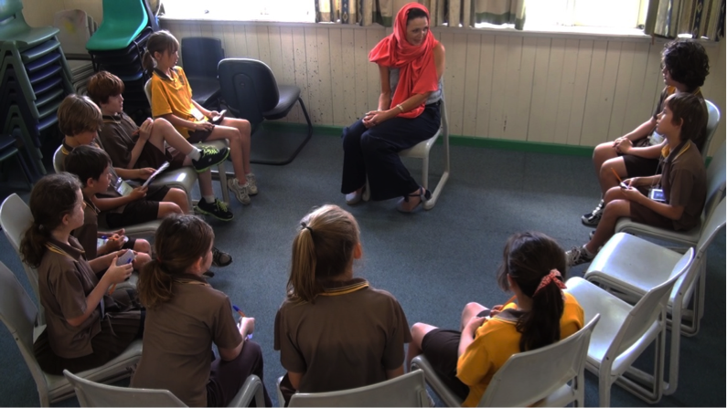 students having a round discussion with a former child labourer